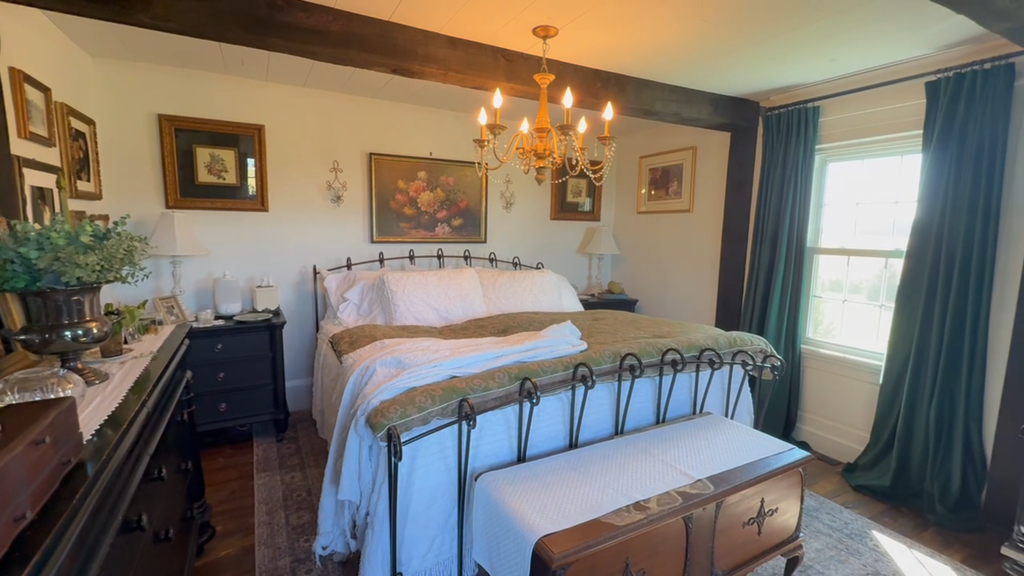 Cozy fall home decor in our historic master bedroom featuring dark green velvet curtains, vintage floral artwork, and romantic cottage style.